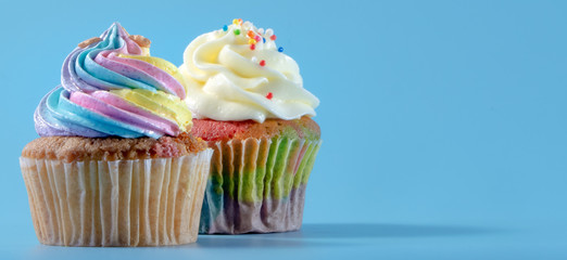 Colorful and enteresting cupcake isolated on blue background studio close up shot.