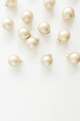 Christmas pattern with golden decoration balls on white background. Flat lay, top view.