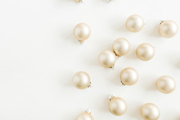 Christmas pattern with golden decoration balls on white background. Flat lay, top view.