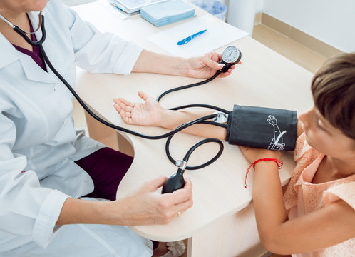 Doctor measuring blood pressure of a little girl.