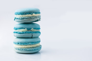 Fototapeta na wymiar French macarons. Stack of blue macaron with dorblu and wine isolated on dark mirror background. Colorful macaroons. Top view