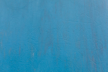 Metal surface painted with blue paint with cracks as a background or backdrop