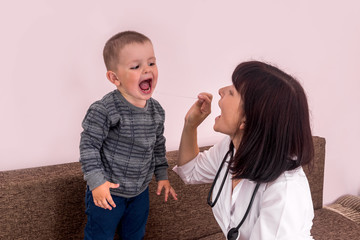 Little boy showing his throat to a doctor