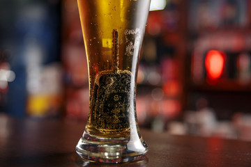 Drinking and driving concept. Car key on a wooden table, pub background