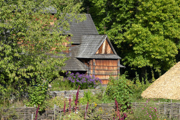 Beautiful old wooden house with wooden gray roof in the summer forest