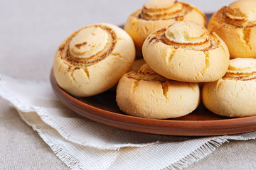 Shortbread cookies in form of champignons. Baked sweet biscuits on clay dishes with copy space. Delicious dessert.