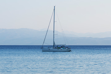 Fototapeta premium Small yacht sailing at dusk