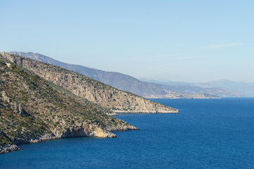 Fototapeta na wymiar Summer time in Greece. Beautiful Greek coastline next to sea shore during warm weather.