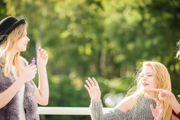 Obraz premium Women friends blowing soap bubbles.