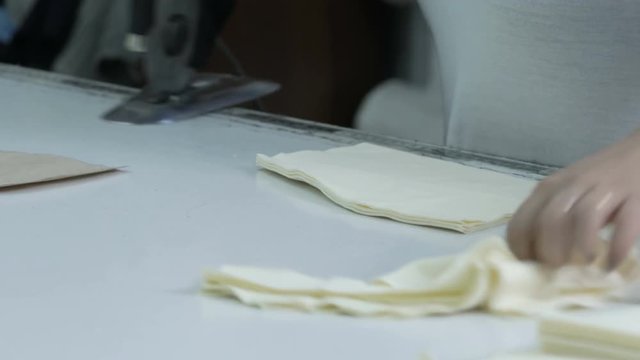 Cutting the fabric, sewing work. Cutting room, cutting light beige cloth tailoring knife. pattern for sewing clothes. cutting on curve