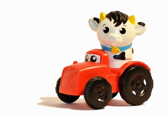 close up of a toy cow driving a truck on a white background 