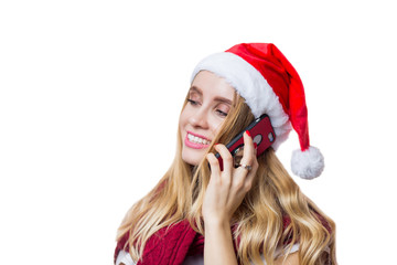 Cheerful happy woman puts on Santa's red hat and talks on her smartphone