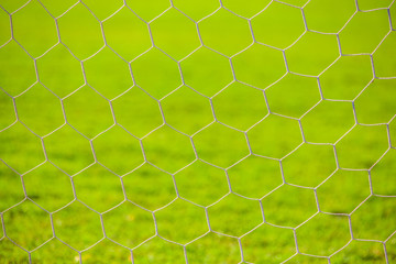 Closeup goal net with green football field background