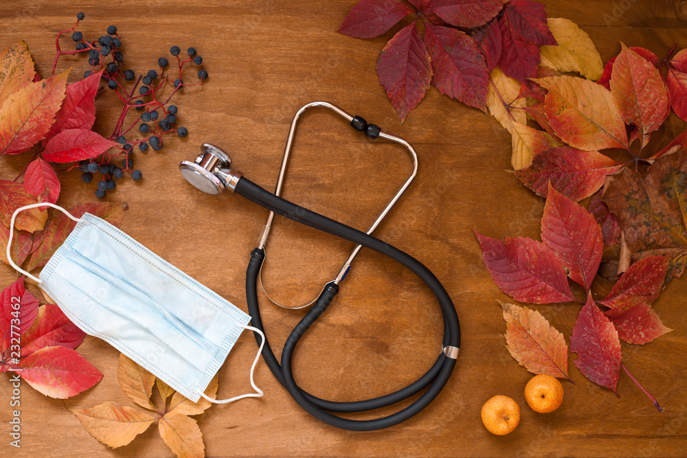 Wall mural doctor stethoscope and yellow leaves autumn background