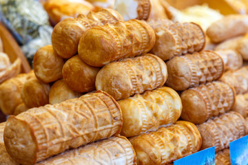Appetizing fresh waffle rolls for sale in the market close-up.