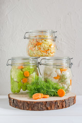 Fermented preserved vegetarian food concept. Cabbage, broccoli, caulie, sauerkraut sour glass jars on white background