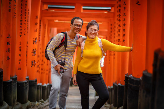 kyoto japan - november9,2018 : couples asian tourist taking a photo in red wood pole of fushimi inari shrine fushimi inari is one of most popular traveling destination in kyoto japan