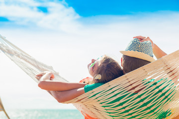Young couple in love relaxing in a hammock by the beach