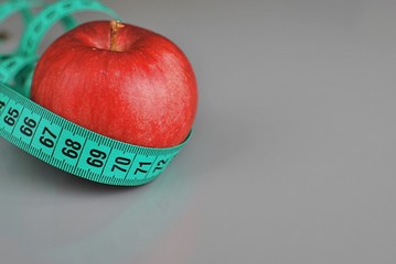Red apple and measuring tape close up, diet, weight loss concept, copy space.