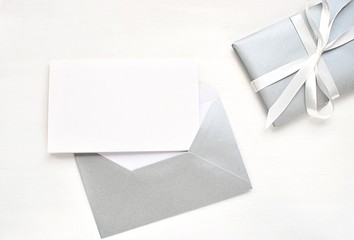 Modern flat lay with blank card and silver envelope, Christmas, New Years, wedding greeting card, invitation mock up.