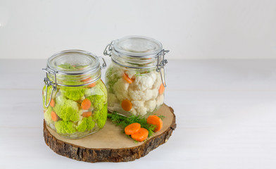 Fermented preserved vegetarian food concept. green cauliflower or broccoli sour glass jars on the...