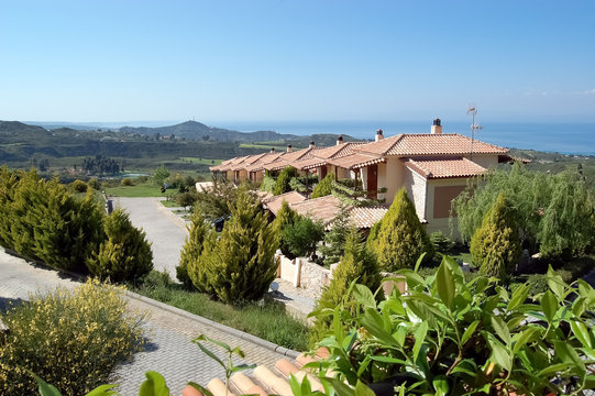 Panoramic views of the scenic mountainous terrain, the blue sea and the villas in Greece.