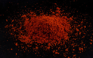 Pile of red paprika powder black background
