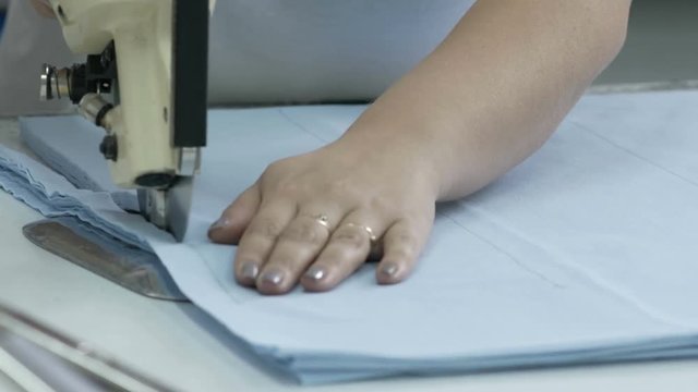 Cutting the fabric, sewing work. Cutting room, cutting blue cloth tailoring knife.