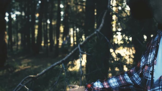 Bearded maniac watching for lost female backpacker in forest, dangerous man