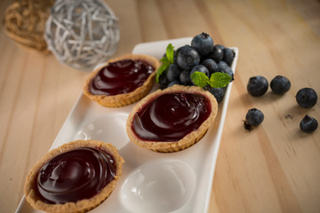 Delicious Blueberry jam tarts, homemade bakery on wooden background, selective focus