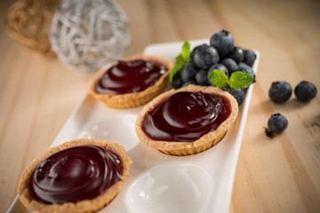 Delicious Blueberry jam tarts, homemade bakery on wooden background, selective focus