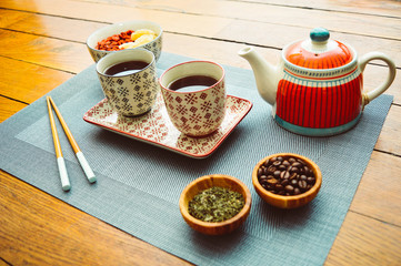 Asian tea set type on wood table with teapot cups bowls chopsticks and food. Culture natural drinks food healthy