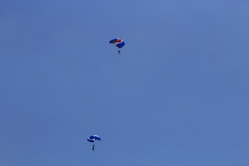 two parachutist on a blue sky background