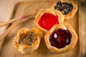 Strawberry and blueberry tart with various jam pies, fresh homemade bakery on wooden background, selective focus