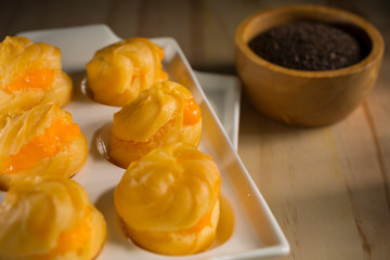Eclair, Homemade cream puffs on wooden background, selective focus, copy space