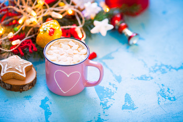 Obraz na płótnie Canvas Cup of chocolate with marshmallow, gingerbread cookies, gifts and beautiful Christmas decorations with lights on the wooden background. Flat lay, top view, close up space for a text.