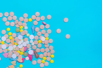 Assorted pharmaceutical medicine pills, tablets and capsules on blue background. Copy space for text. Medicine. top view