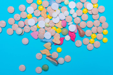 Assorted pharmaceutical medicine pills, tablets and capsules on blue background. Copy space for text. Medicine. top view