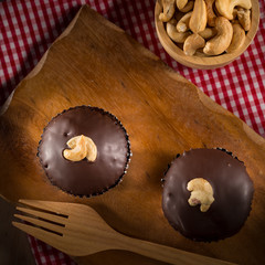 Chocolate cupcake with Cashews on top, Homemade Dark Chocolate Cupcake on wooden blackground, selective focus