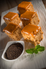 Milk tea cake with dried tea leaves, homemade bakery on white dish, selective focus