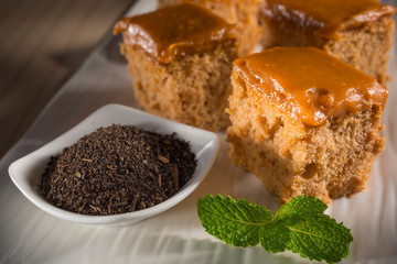 Milk tea cake with dried tea leaves, homemade bakery on white dish, selective focus