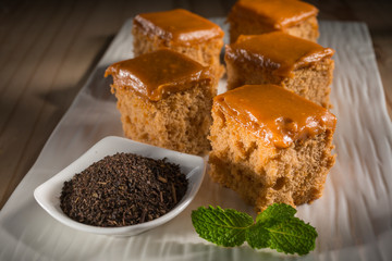 Milk tea cake with dried tea leaves, homemade bakery on white dish, selective focus