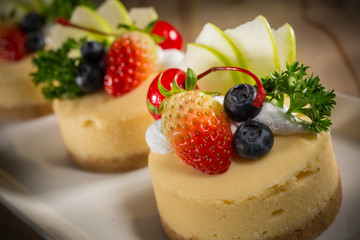 Cheesecake With Fruit Topping, Mixed fruit Cheesecake, Homemade cake on white dish, selective focus