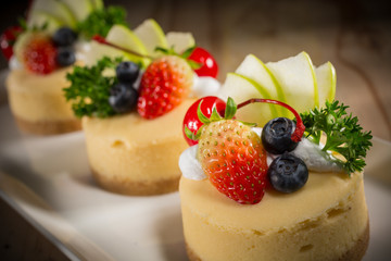 Cheesecake With Fruit Topping, Mixed fruit Cheesecake, Homemade cake on white dish, selective focus