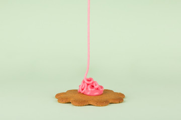 gingerbread decorating with icing, Pink Icing and Green background. Gingerbread isolated and centered.