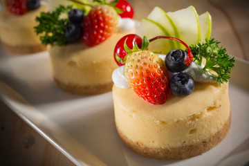 Cheesecake With Fruit Topping, Mixed fruit Cheesecake, Homemade cake on white dish, selective focus