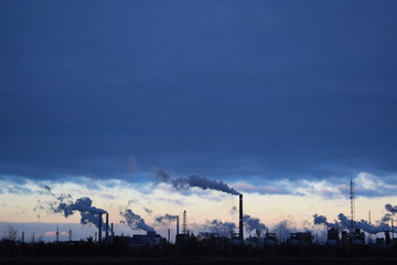 The plant emits smoke and smog from the pipes at sunset, pollutants enter the atmosphere....