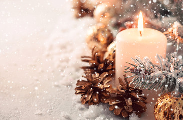 Beige snow Christmas composition. Burning candle and fir cones