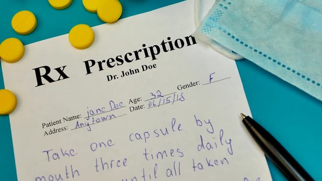 Prescription for tablet pills or drugs on blue background with bottle and yellow tablets or pills and medical mask