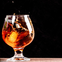 glass of whiskey and ice on black background